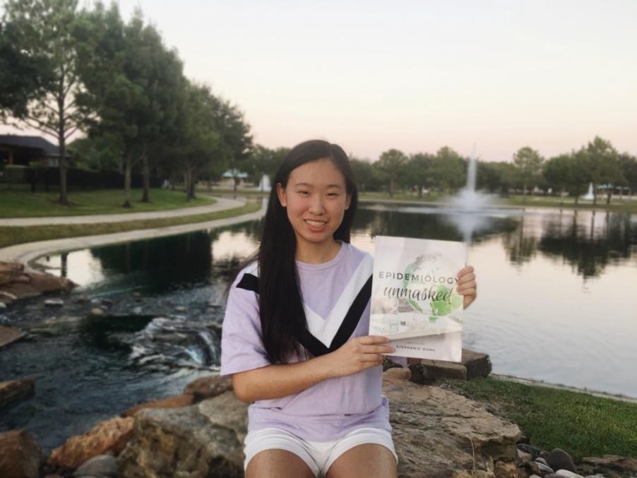 Girl holding her own book called "Epidemiology Unmasked"