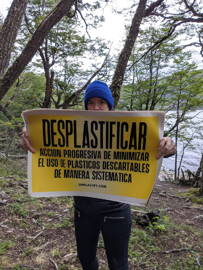woman holding a sign about deplastifying